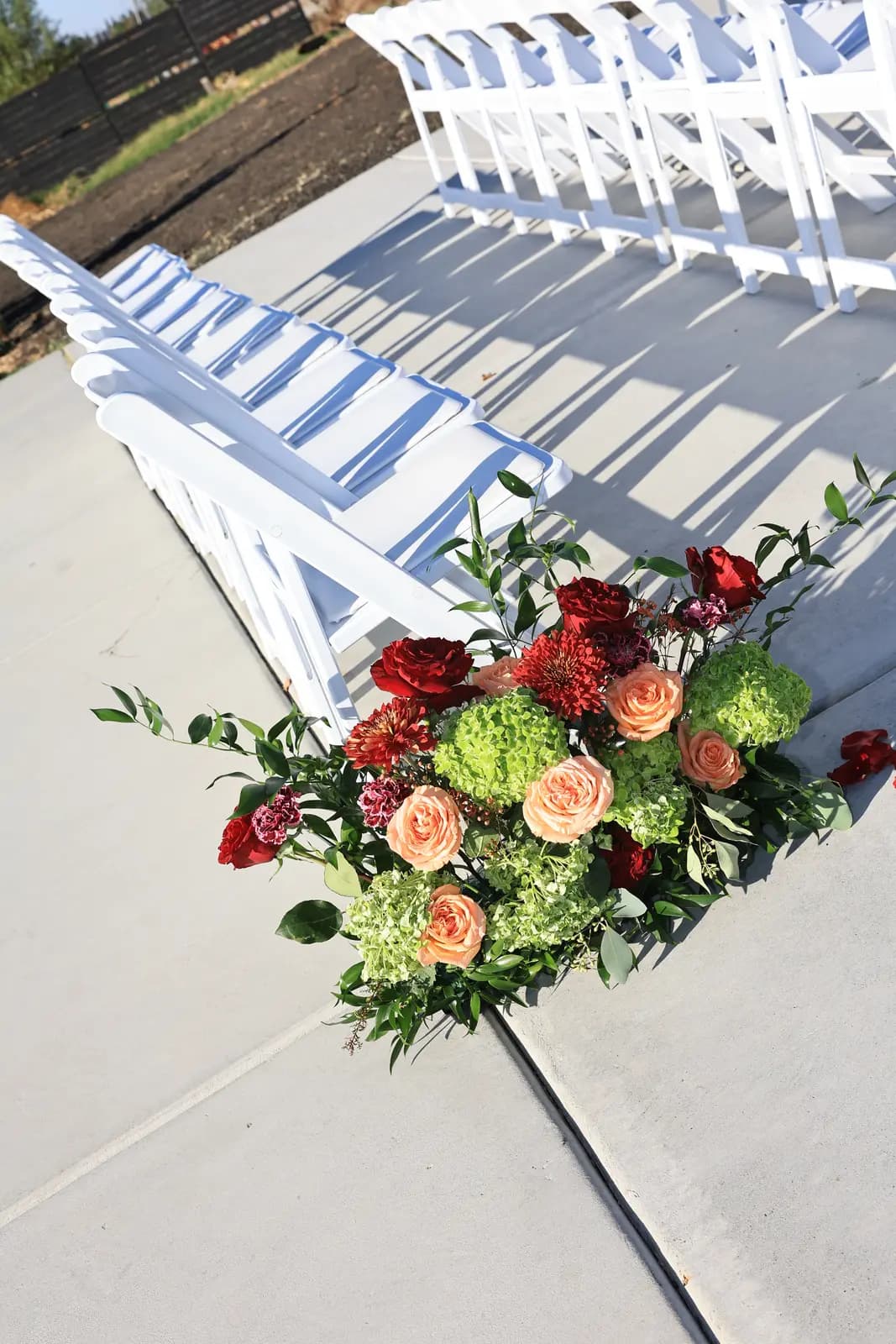 Green hydrangea, dahlia, and rose arrangement anchoring the ceremony aisle